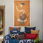 A vintage living room with a hand-painted John Robshaw Prince Admiring Tapestry hanging above a couch. - 30148882104366