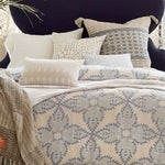 A bed with blue and white Dasati Duvet Set bedding made of linen and cotton, adorned with pillows. - 14684731408430