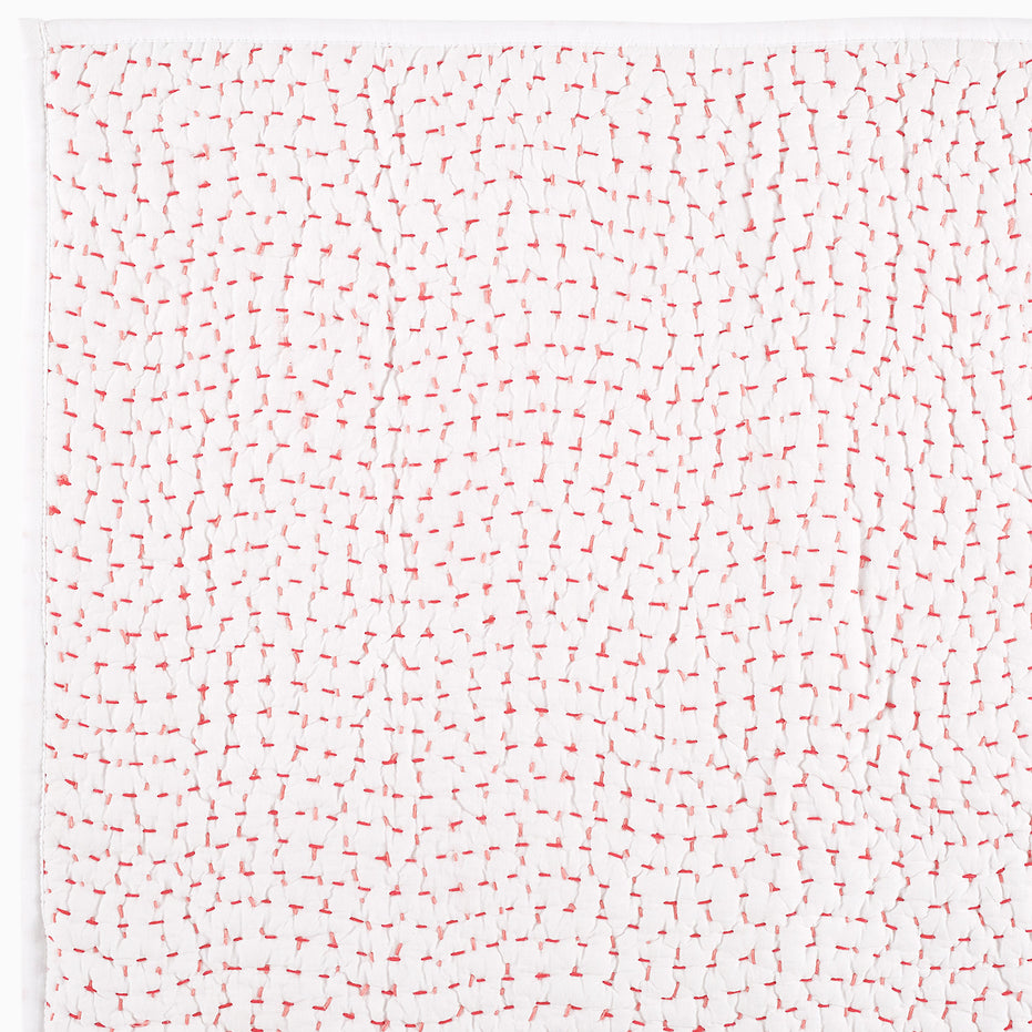 A white piece of Organic Hand Stitched Lotus Quilt paper with hand-stitched red and white lines on it.