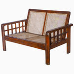 A Vintage Furniture loveseat with grid arms and a rattan seat. - 29225296560174