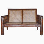 A Vintage Furniture loveseat with grid arms and a rattan seat. - 29225296527406