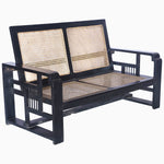 A modern John Robshaw black loveseat with curved arms and a vintage rattan seat. - 29225383460910
