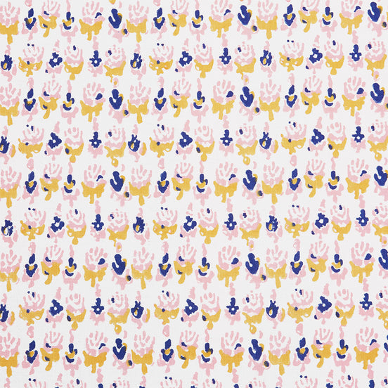 A close up of a Kiki Oyster Fabric hand block printed pink, blue and yellow flower batik by John Robshaw.