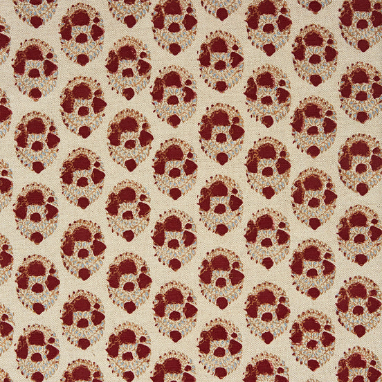 A red and beige floral pattern on a white background, created using traditional craftsmanship using the Kukkuta Teak Fabric by John Robshaw.