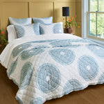 A bed with a blue and white John Robshaw Lapis Peacock Quilt. - 30064554868782