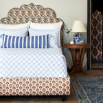 A Layla Azure Quilt bed with a blue and white patterned headboard inspired by Mughal gardens, designed by John Robshaw. - 30262778396718