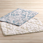 Two Pasak Blue Bath Rugs by John Robshaw on a wooden floor. - 28268378980398