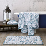 A bathroom with a John Robshaw Pasak Blue Bath Rug and bath towels. - 28268379078702