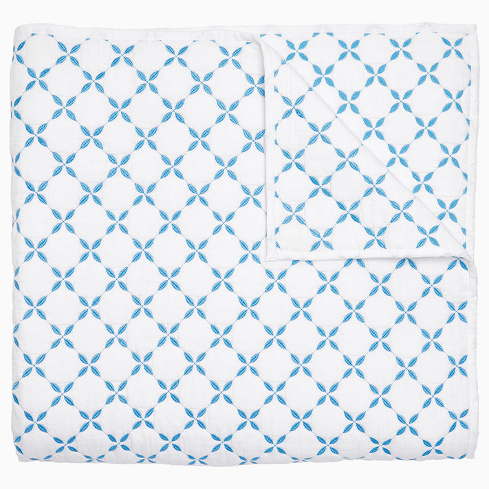 A Layla Azure Quilt by John Robshaw, a cotton voile blue and white blanket with a geometric pattern inspired by Mughal gardens.