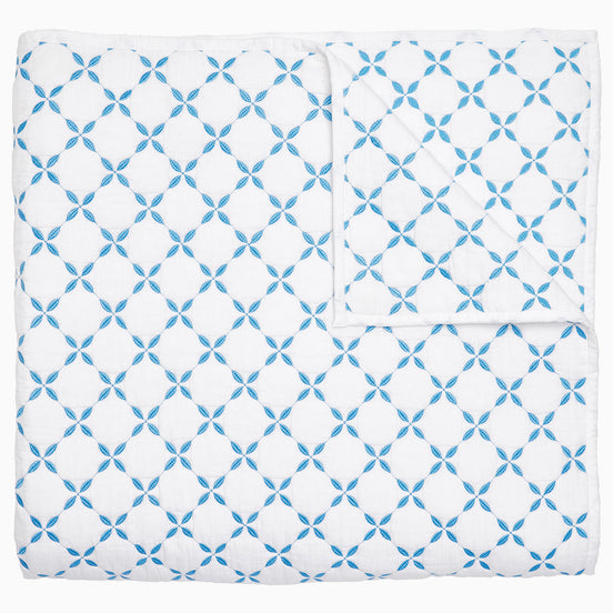A Layla Azure Quilt by John Robshaw, a cotton voile blue and white blanket with a geometric pattern inspired by Mughal gardens.