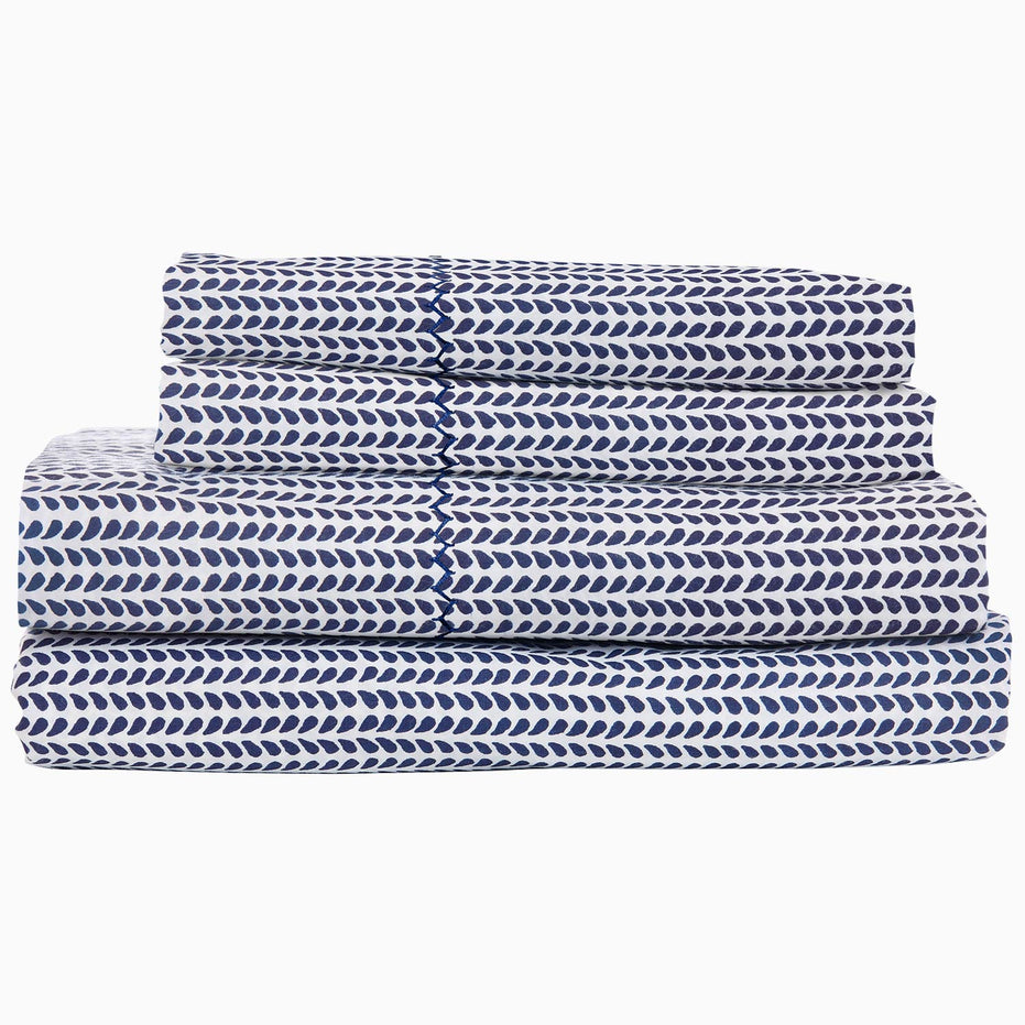 A stack of 200 Cinde Indigo Organic Sheet Set by John Robshaw, indigo and white patterned sheets.