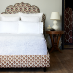 A white bed with an ornate headboard made of John Robshaw's Organic Hand Stitched Sand Quilt. - 30262778789934