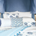 A bed with Sahati Indigo Bolster bedding by John Robshaw and a canopy. - 14839370154030