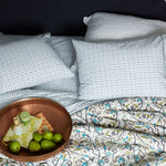 A bed with Sag Harbor Peacock Organic Sheets pillows and a bowl of machine washable fruit. - 28362871242798