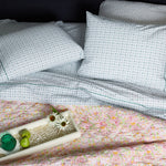 A bed with Sag Harbor Peacock Organic Sheets pillows and a tray of John Robshaw organic cotton fruit. - 28362871210030