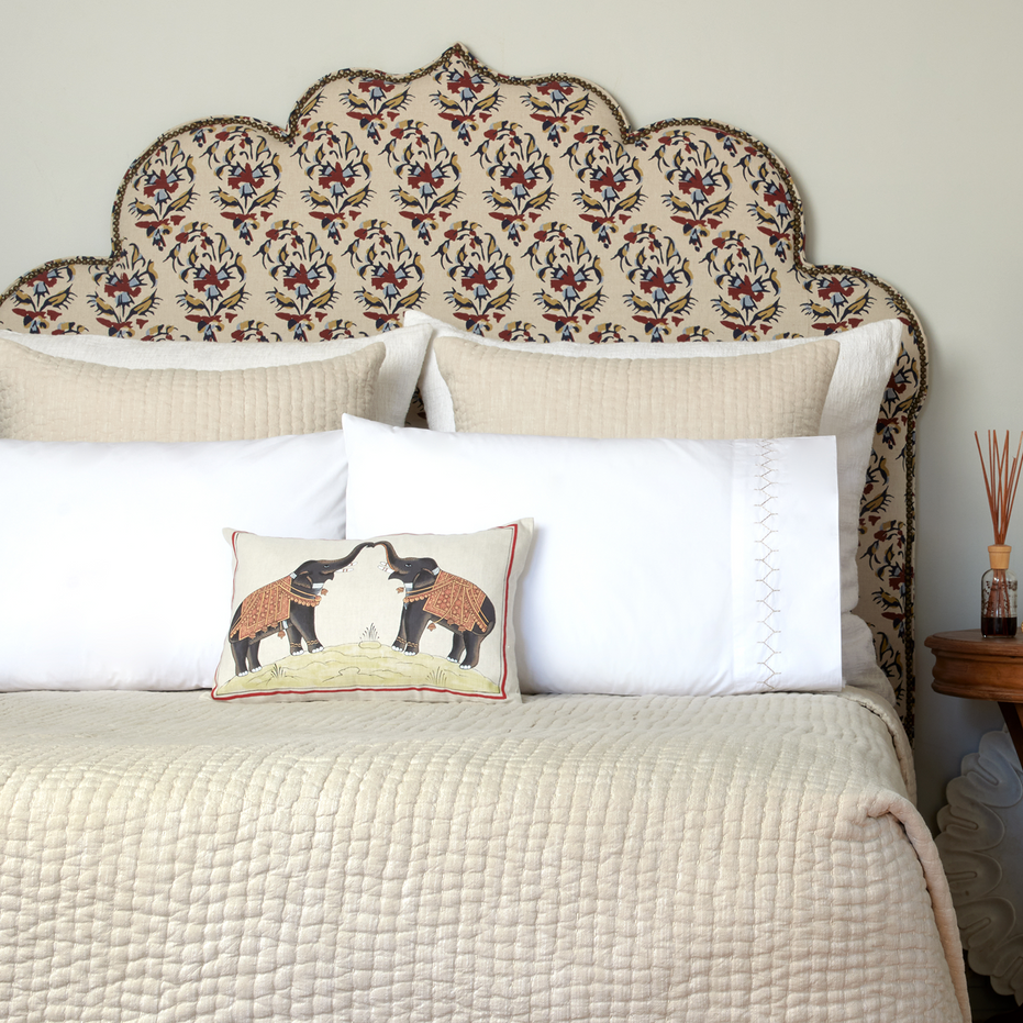 A white bed with a John Robshaw Two Elephants Decorative Pillow on it.