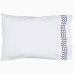 A white Sana Indigo Organic Sheet Set pillow with a blue trim featuring hand embroidery from the brand Sheets & Cases. - 28765990027310