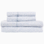 A stack of Vamika Periwinkle organic cotton sheets with a floral pattern by John Robshaw. - 28766002249774