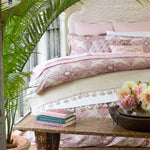 A Lotus colorway bed with a pink and white comforter and pillows from the Dasati Lotus Duvet Set by John Robshaw. - 28783107964974