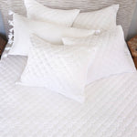 A Layla White Quilt from Quilts & Coverlets with reversible pillows on it. - 28783173992494