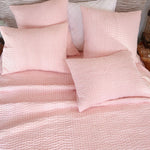 A bed with a Vivada Blush Woven Quilt from Quilts & Coverlets and hand-stitched pillows. - 28783151120430