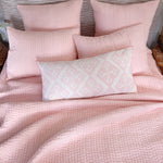 A bed with the Quilts & Coverlets Vivada Blush Woven Quilt and hand-stitched pillows. - 28783151087662