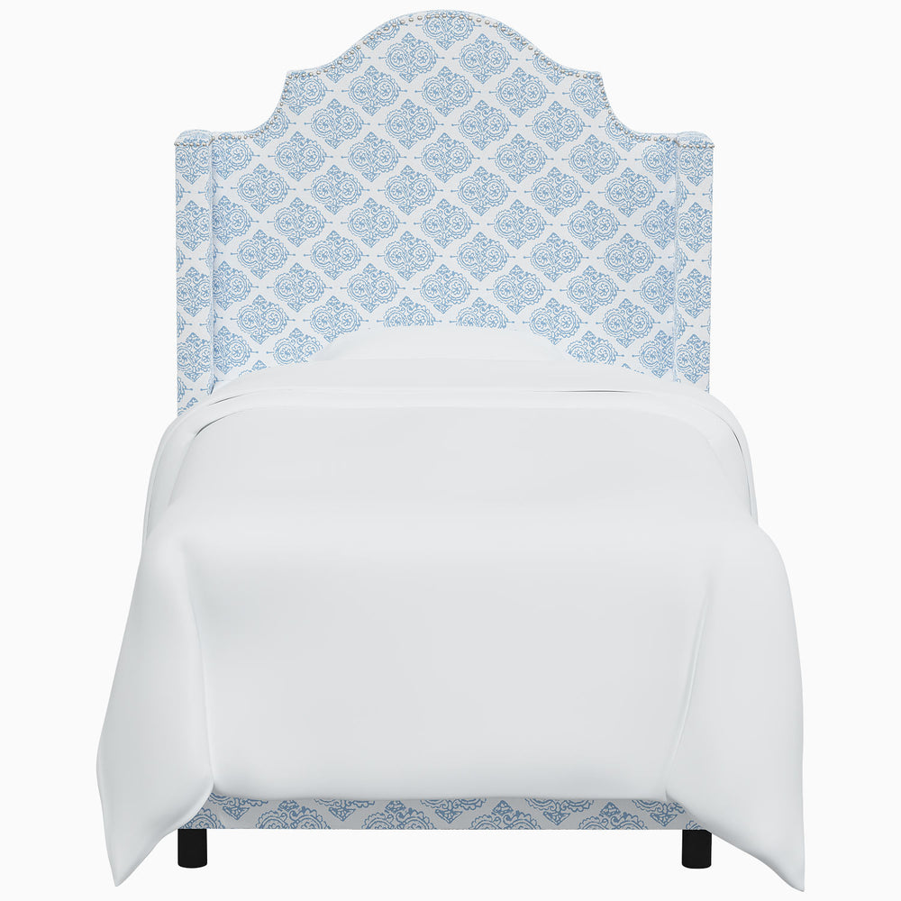 A white bed with a blue damask pattern by John Robshaw's Samrina Bed.