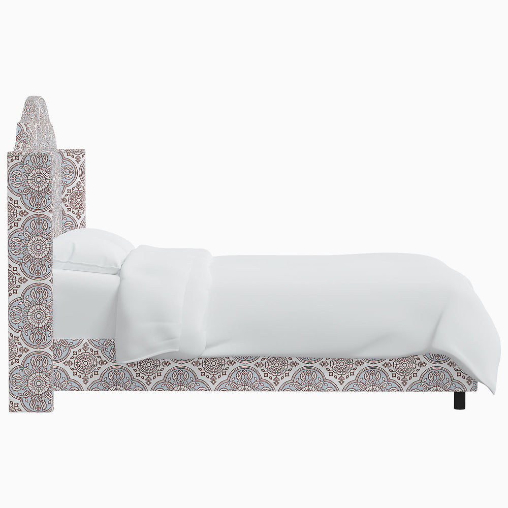 The John Robshaw Samrina bed features a white bed with a pattern on the headboard inspired by Mughal arches.