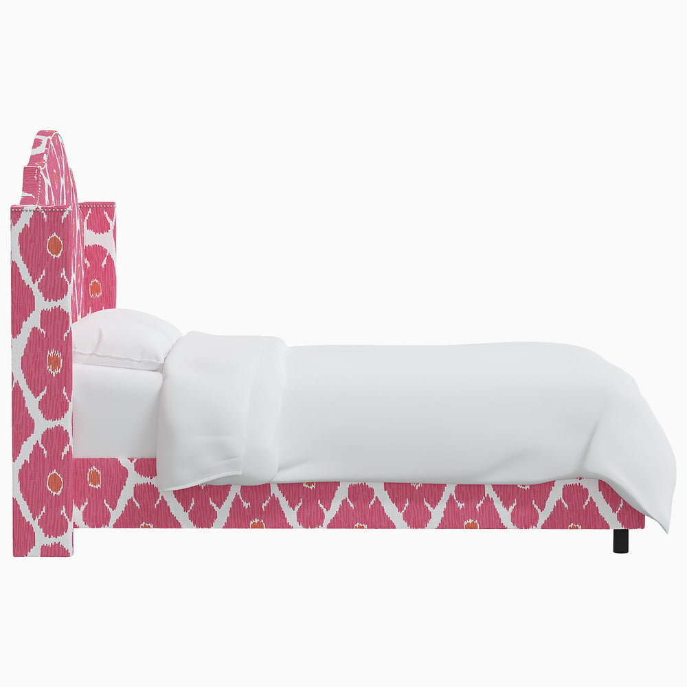 The John Robshaw Samrina bed, with its Mughal arches design, features a pink and white upholstery that beautifully complements the white headboard.