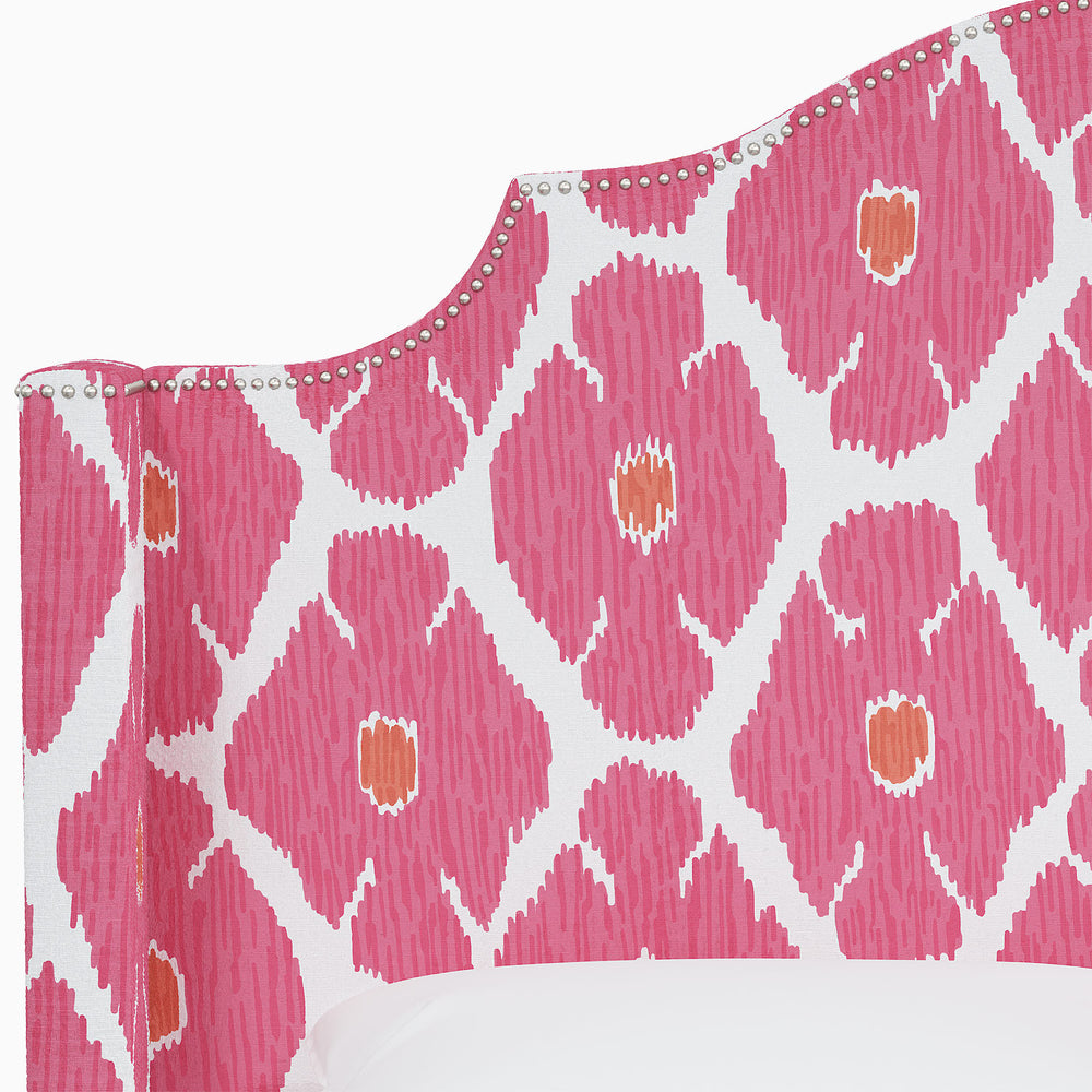 The John Robshaw Samrina bed features a vibrant pink and orange patterned headboard adorned with Mughal arches.