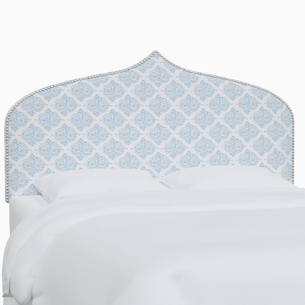 A white bed with an Alina headboard from John Robshaw featuring Mughal arches.