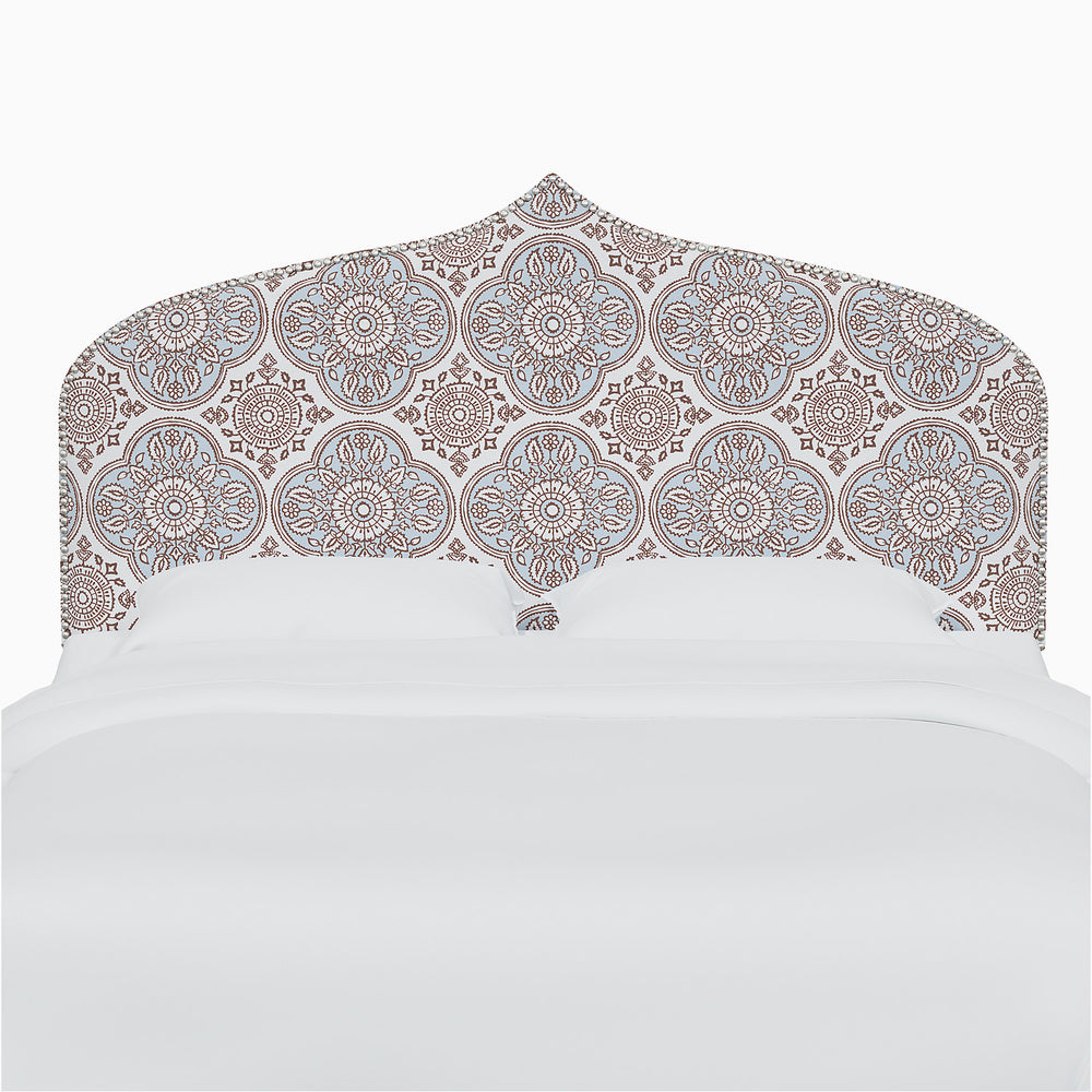 A blue and white John Robshaw Alina headboard adorned with intricate Mughal arches prints.