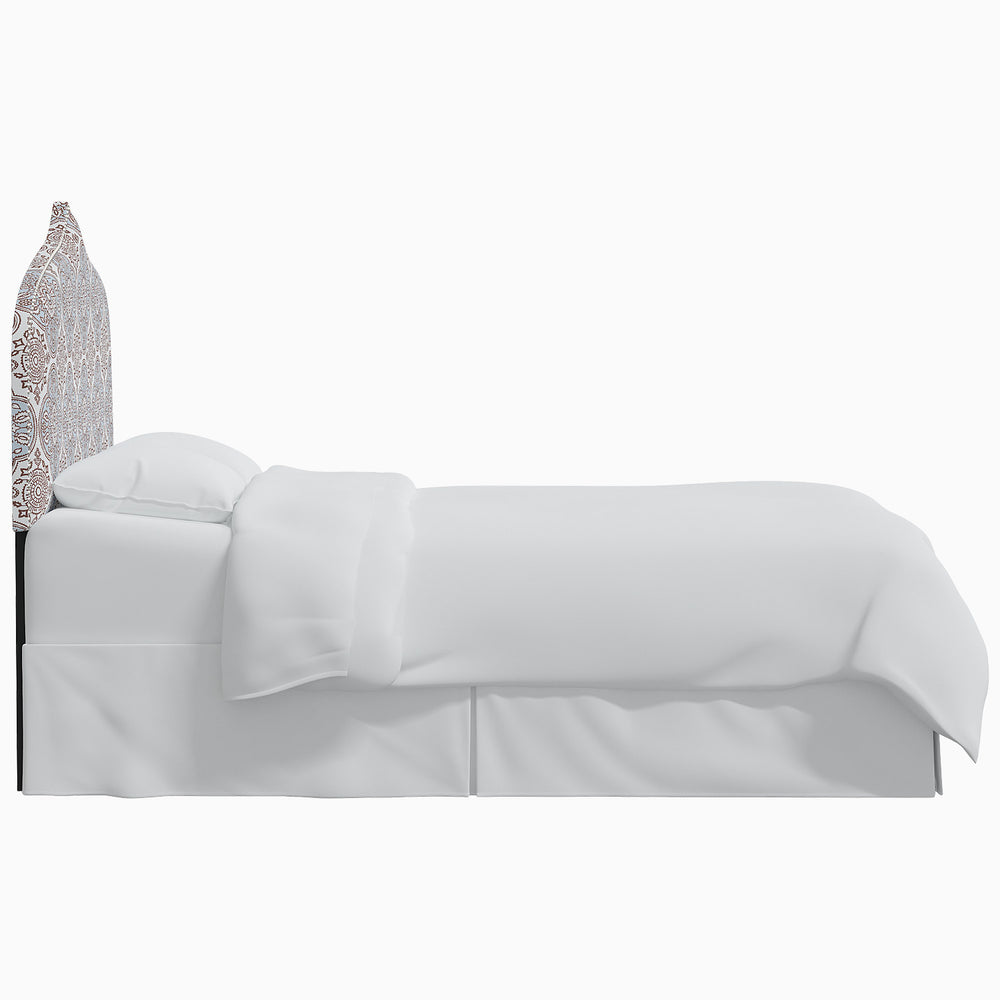 A white bed with a John Robshaw Alina headboard.