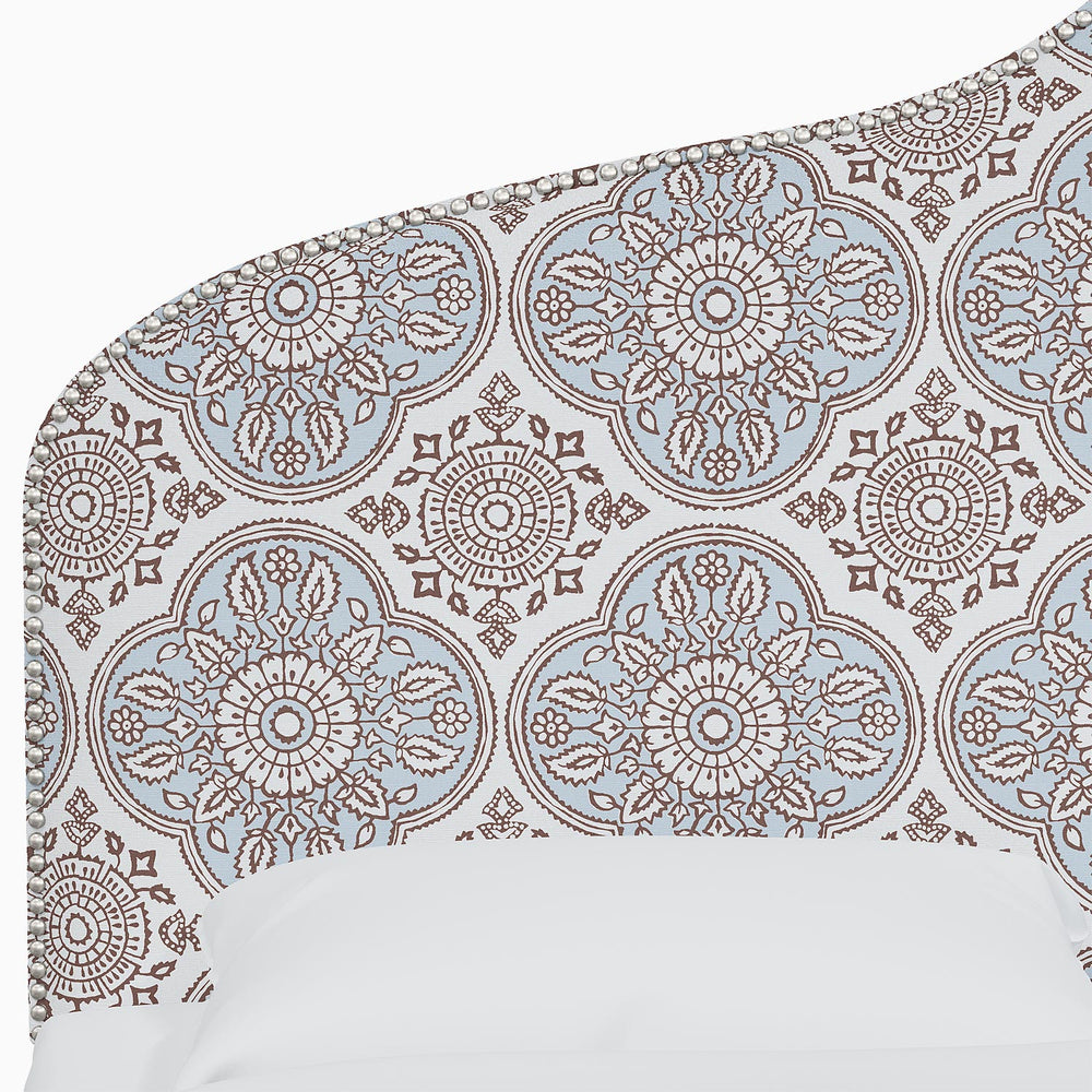 A bed with a blue and brown Alina Headboard featuring Mughal arches and intricate prints by John Robshaw.
