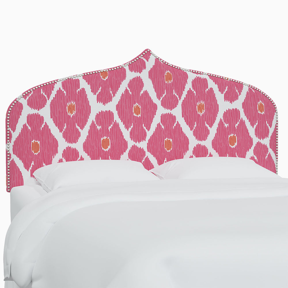 A bed with a pink and white John Robshaw Alina headboard.
