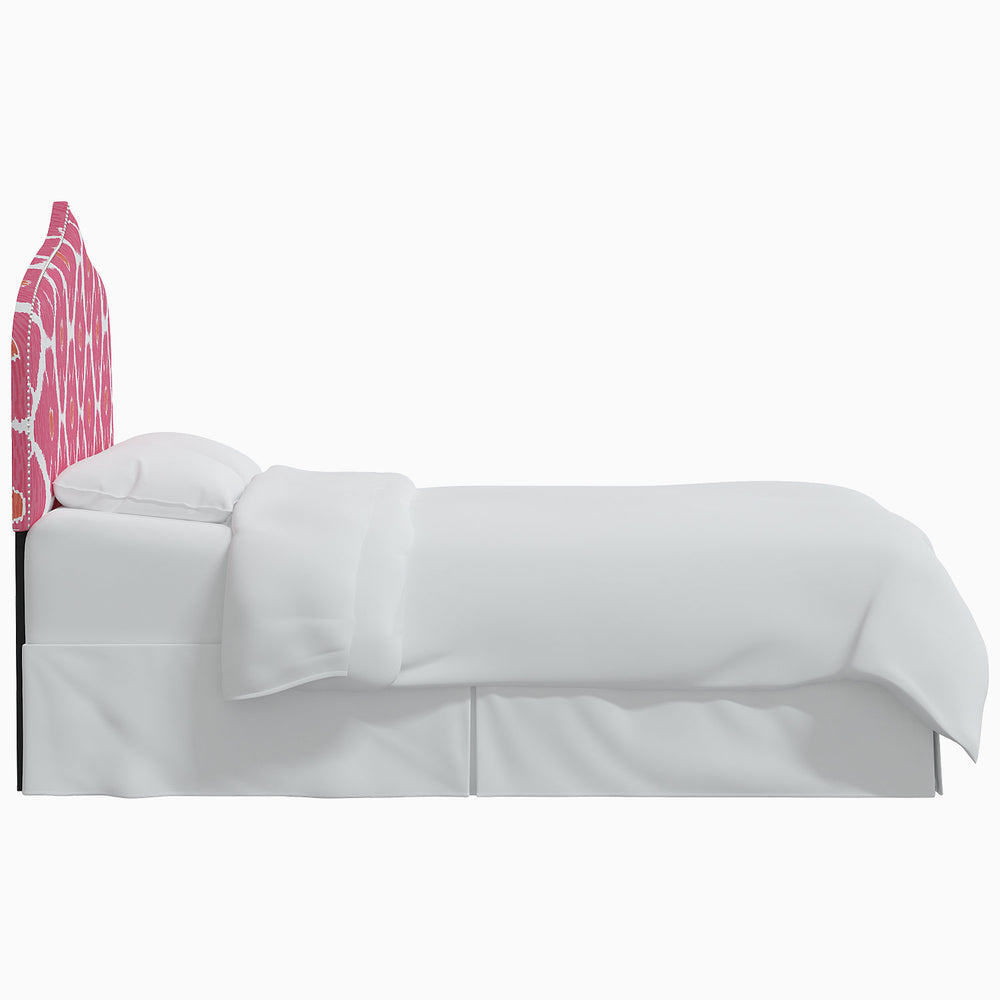 A white bed with a pink John Robshaw Alina Headboard.