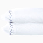 A pair of white Stitched Indigo Organic Sheets pillowcases with blue embroidery from the brand Sheets & Cases. - 30271866732590