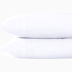 A pair of Stitched White Organic Sheets with embroidered designs on a white background by John Robshaw. - 30252490588206