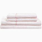 A stack of Poseti Lotus Organic Sheet Set by John Robshaw pink sheets. - 30252461260846