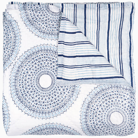 A handcrafted Lapis Quilt with a circular pattern, featuring a vintage woodblock design by John Robshaw.