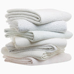 A stack of Quilts & Coverlets' Organic Hand Stitched White Quilts on a white background. - 29305610862638
