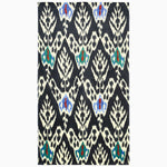 A black and white John Robshaw Uzbekistan rug adorned with a vibrant Umida Ikat Black Beach Towel pattern. - 30253928710190