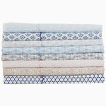 A stack of blue and white Kama Light Indigo Organic Sheet Set made by Sheets & Cases which is machine washable. - 28202300145710