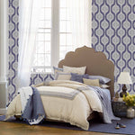 A bedroom with blue and white wallpaper featuring John Robshaw Sahati Indigo Throws on the hand-stitched bed. - 11324220538926