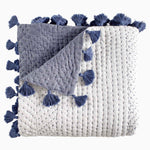 A soft fabric, hand-stitched Sahati Indigo Throw blanket with tassels made by John Robshaw. - 30252445237294