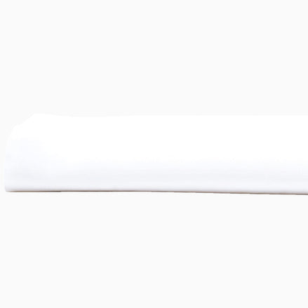 A John Robshaw Organic White Fitted Sheet, made of organic cotton, lying on top of a white surface in India.